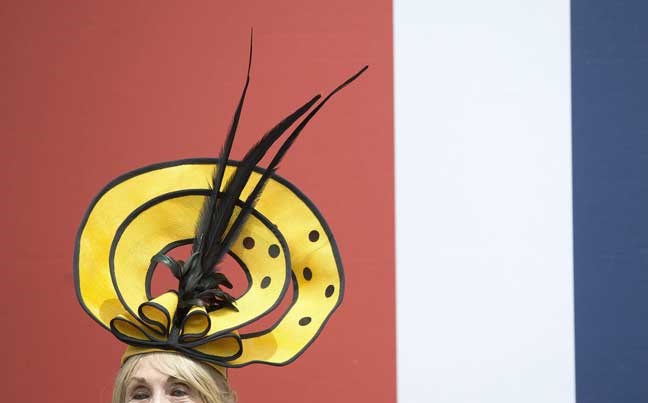 Florence Claridge pose for the media in a yellow hat on the second day of the Royal Ascot horse race meeting in Ascot, England, Wednesday, June 19, 2013. (AP Photo/Alastair Grant)