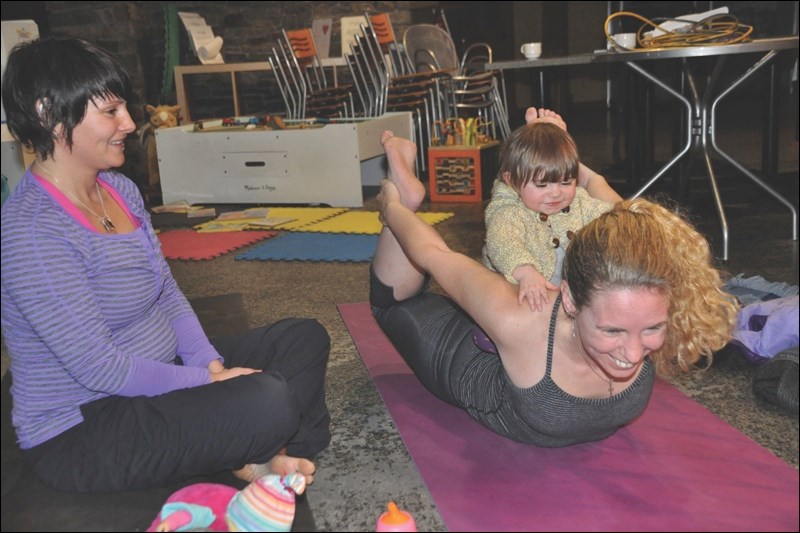 Youngster Frankie Campbell rides on the back of Yvonne Leblanc while mother Kristin Campbell looks on.