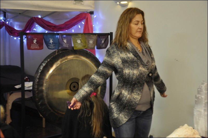 Laura Berdette from Anniebelle's Sunshine Healing uses the sonic waves of the gong to heal a customer.