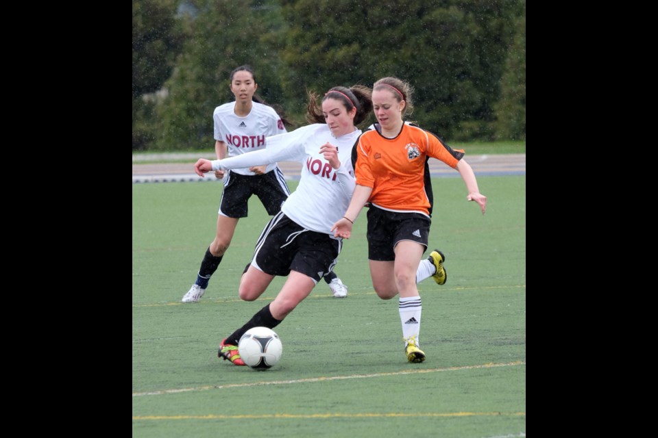 New Westminster's Emily Butts, in orange, fights for a ball in an earlier game against eventual playoff finalist Burnaby North