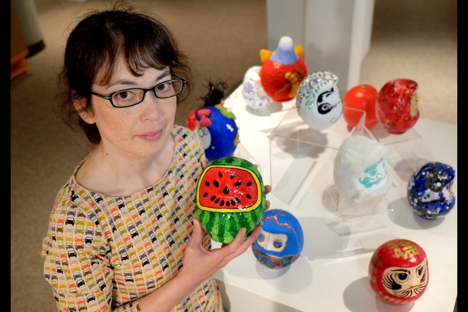 Nichola Ogiwara of the Nikkei National Museum and Cultural Centre with some of the daruma that will be up for auction at the museum's fundraising Bloom Art Auction. The daruma are on display at the Nikkei Centre until May 24.
