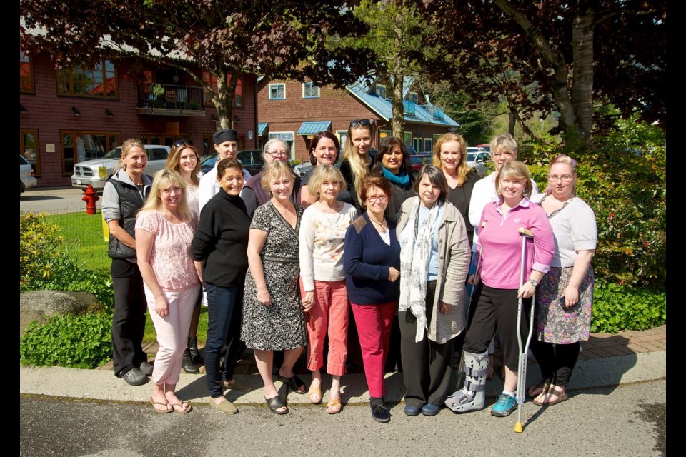 Artisan Square business owners gather for a dose of sunshine and a group shot.