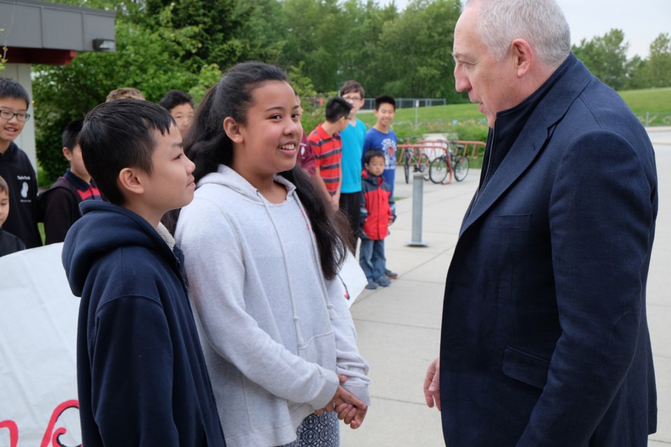 Students Nathan Cho and Mae Ausena greet Bramwell Tovey at Taylor Park Elementary.