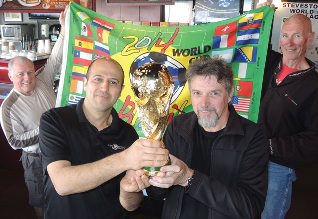 Café owner Davood Khatami, left, and chocolatier Dominique Jarry hold up a replica of the World Cup as they kick off the 28-day countdown to the international soccer tournament that will see Steveston transform into a global village.