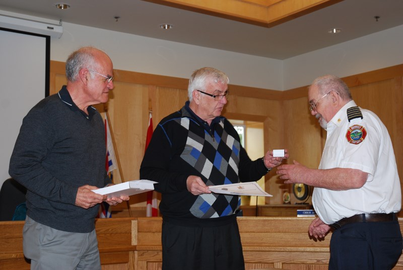 Egmont/Pender Harbour director Frank Mauro (left) and SCRD board chair Garry Nohr present awards to retiring Egmont Fire Chief Peter Sly at the May 8 community services committee meeting.