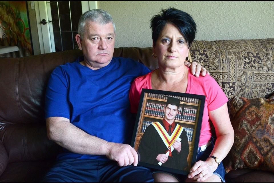 Burnaby parents Mike and Marcella Hague hold a photo of their son Mark, who died a year ago today, and whose memory will be honoured with a mentorship bursary at Burnaby North Secondary.