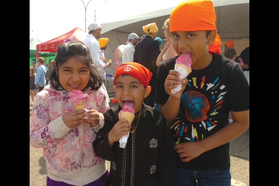 Gurman Punn, 8, left, Harsh Patyal, 5, and Sukhman Singh, 8, enjoyed bubblegum ice cream from Kaurs United and Punjabi School booth at the CN Centre parking lot.