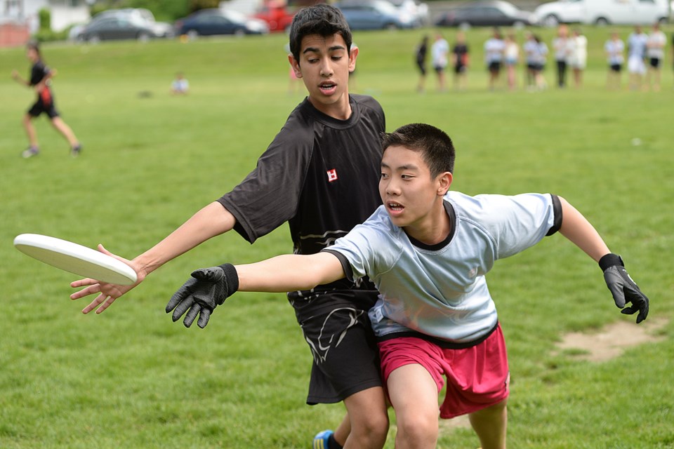 Devin Meng releases the disk out of reach of Jeevan Dhinsa in a Stratford Hall inter-team scrimmage on May 22, 2014.