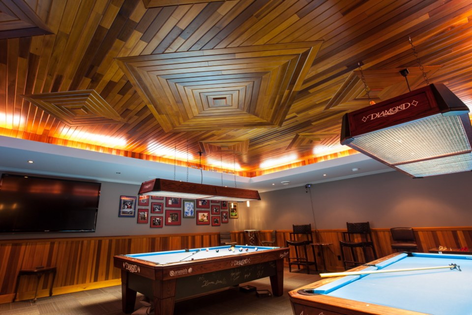 The homeowner designed the ceiling pattern on his computer, and it was recreated in the billiards room using clear cedar. He says the custom-patterned wood ceiling reminds him of pool halls heÕs played in.
