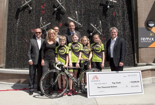 On behalf of Adera Development, CEO Kevin Mahon, together with Eric Andreasen, Adera’s vice-president of sales and marketing, present a $10,000 cheque to Lesley Tomlinson and young cyclists of TaG Youth Cycling program. The donation was made at the grand opening of Adera’s Remix project at 733 West 14th St.