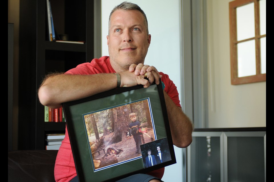 Marc Smith poses with a photograph showing one of his happiest memories — camping with his dad, Ian. Photo Dan Toulgoet