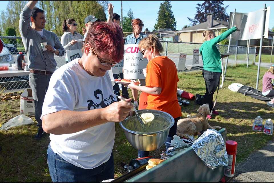 Cariboo Hill Secondary home economics teacher Jayne Roberts supplies pancakes and bacon to teachers and support staff picketing during rotating teacher strikes in Burnaby Wednesday.