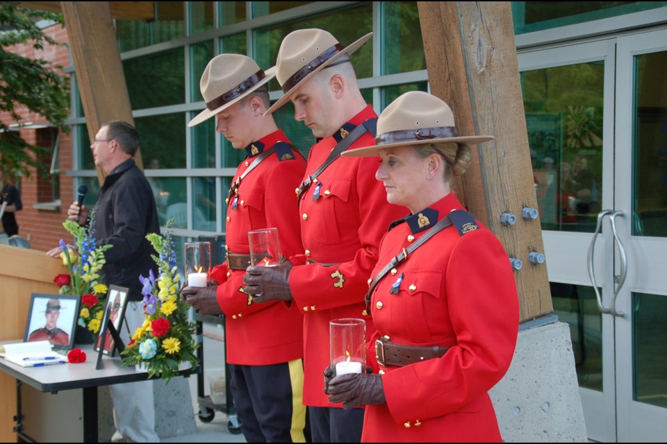 RCMP Chaplain Andrew Barker addresses the crowd gathered for a candlelight vigil in honour of the RCMP officers slain in Moncton on June 4, while Sunshine Coast Constables Kyle Hrynyk, Chelsey Johnson and Andrea Ceulemans hold candles to symbolize the lives of the men who died. The candles were ceremoniously blown out after the crowd observed a moment of silence for each officer during the vigil at the Sunshine Coast detachment on June 9. Photos of the three constables who were killed in the line of duty were on display: Dave Ross, Fabrice Georges Gevaudan and Douglas James Larche.