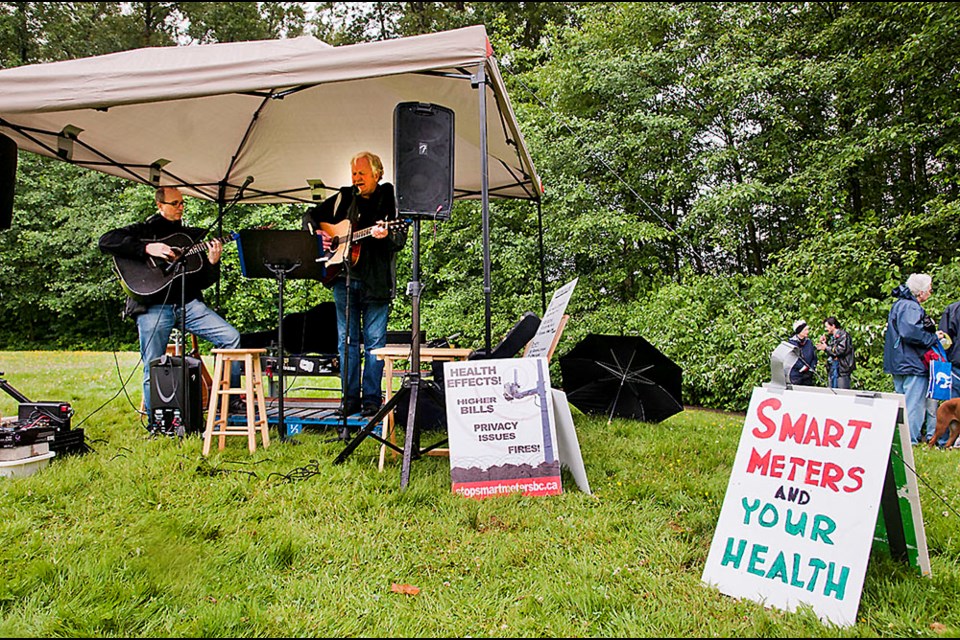 From left, Carl Kartz and Dennis Pederson sang protest songs at the anti-smart meter rally in Burnaby on Saturday.