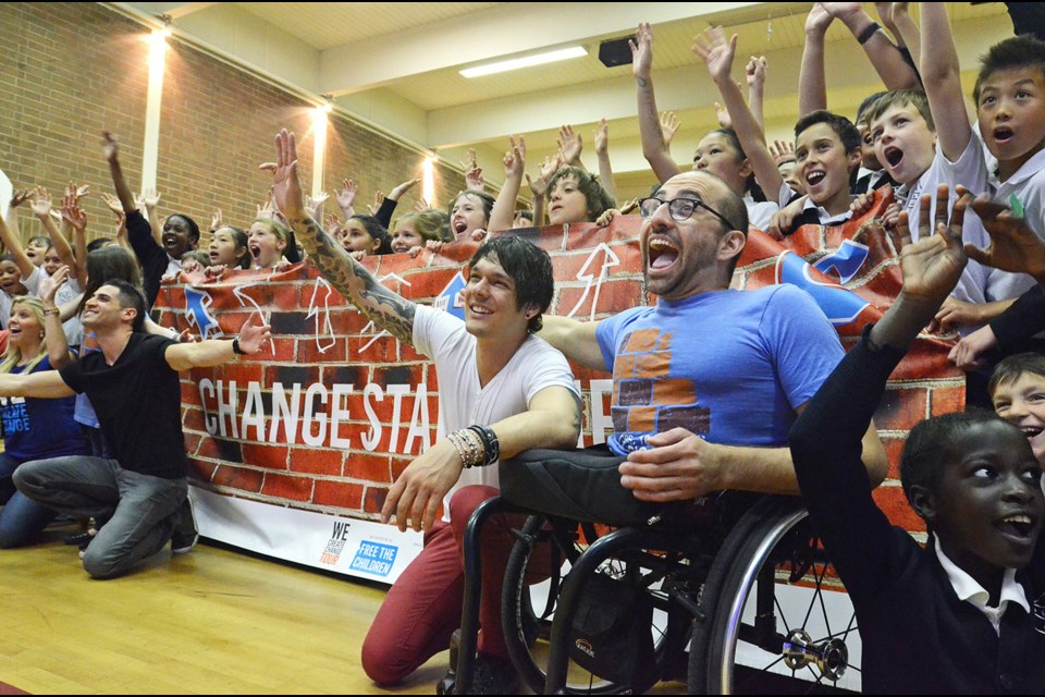 Free the Children motivational speaker Spencer West (in blue) celebrates fundraising success with students at Burnaby’s St. Francis de Sales Elementary School Thursday as part of Free the Children’s cross country We Create Change Tour.