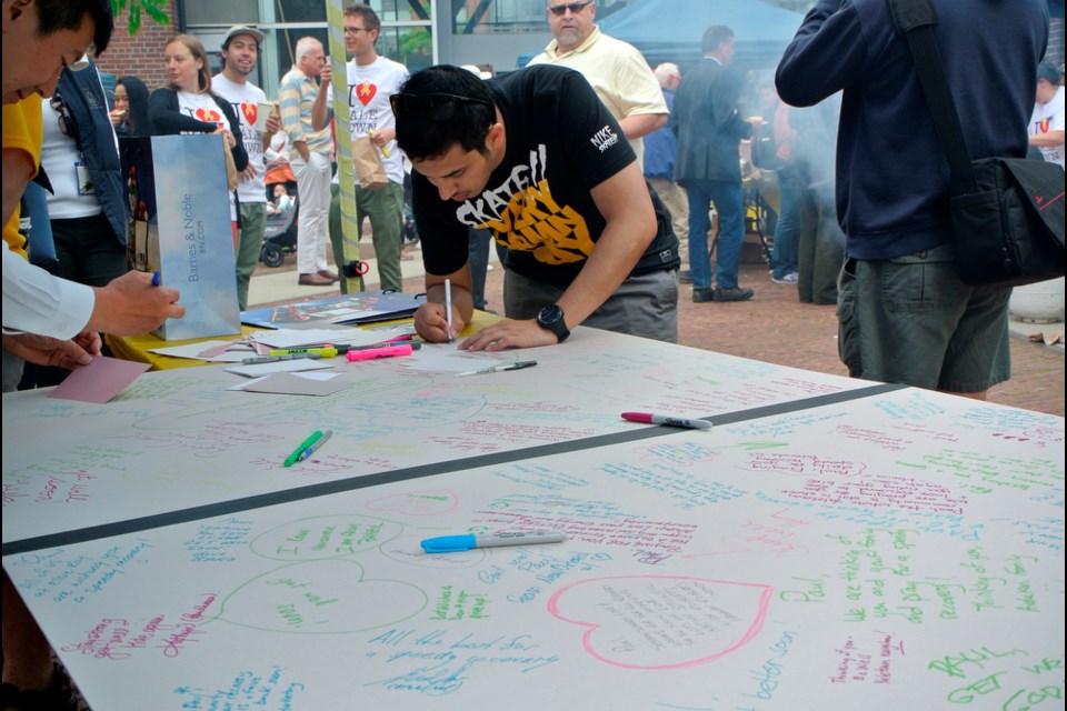 Visitors signed a card for shooting victim Paul Dragan. Photo Christopher Cheung