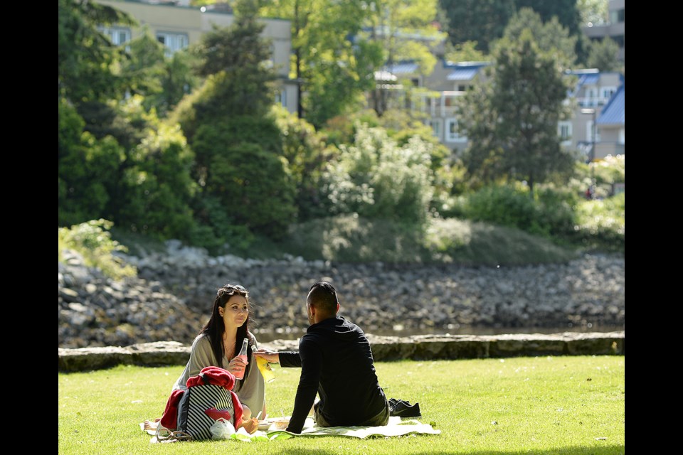 Anna Weng and Zuber Jiwa enjoy some warm weather by having an afternoon picnic on Granville Island. Photo Dan Toulgoet