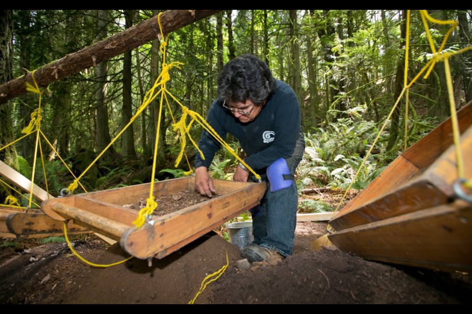 First Nations advisor Phillip Joe works with students on a shell midden archaeology dig on Prevost Island.