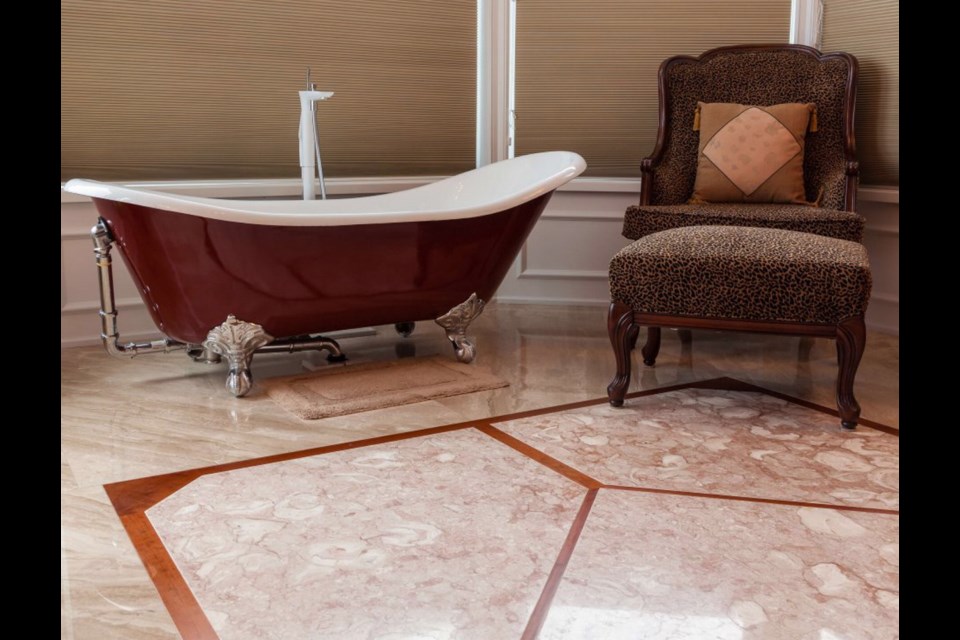 Luxury abounds with a marble floor and a stand alone clawfoot tub.