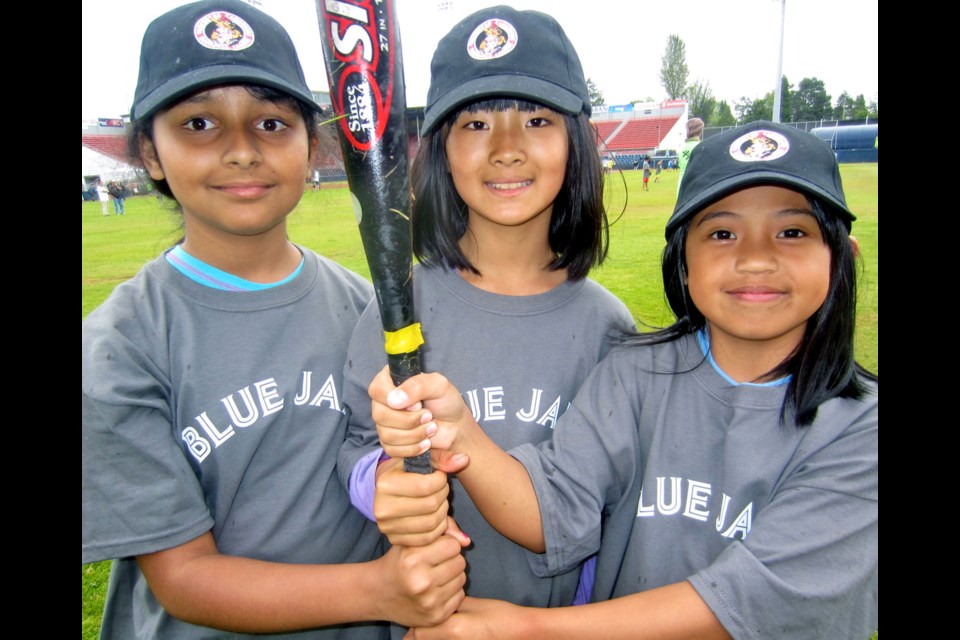 From left, Ganga Sapkota, Yoyo Hu and Ira Bacagan were among the children between the ages of six and eleven that suited up to play organized baseball at Nat Bailey stadium.