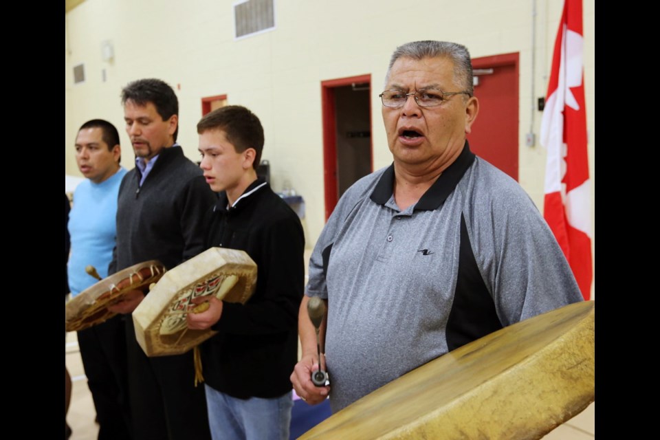 Tsartlip Chief Wayne Morris, right, drums with Pauquachin Chief Bruce Underwood, second from left, and his son Landon, 14, at the ceremony Friday to turn a Goldstream parcel of land back to Saanich Tribes.
