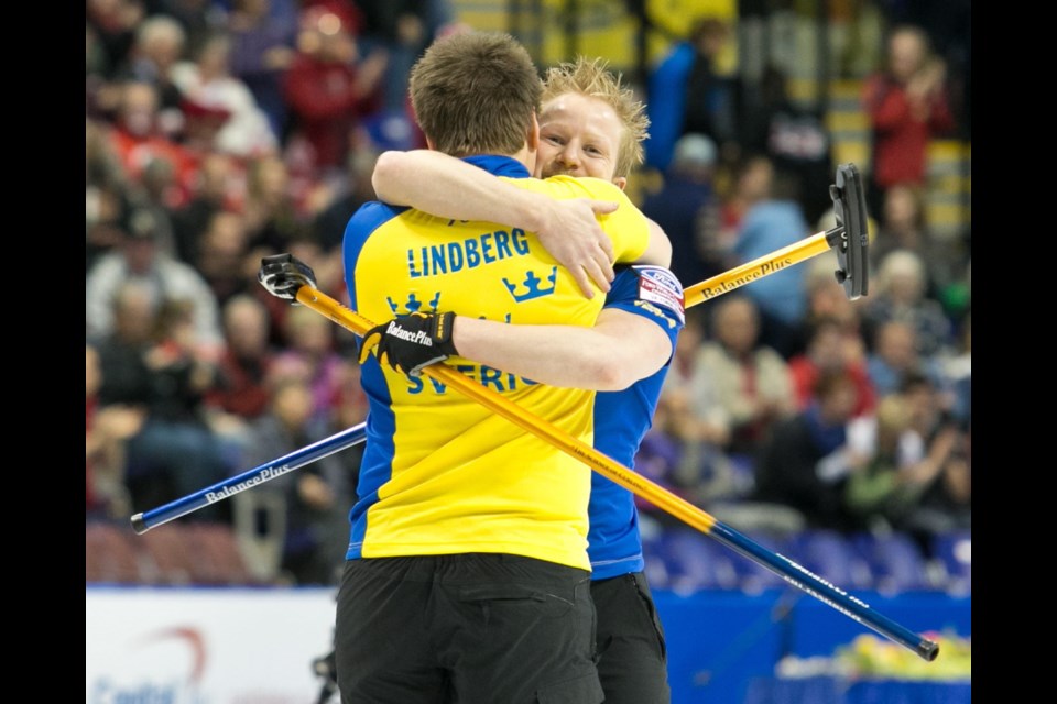 Swedish skip Niklas Edin (facing camera) embraces second Fredrik Lindberg upon winning the 2013 Ford World MenÍs Curling Championship on Sunday.