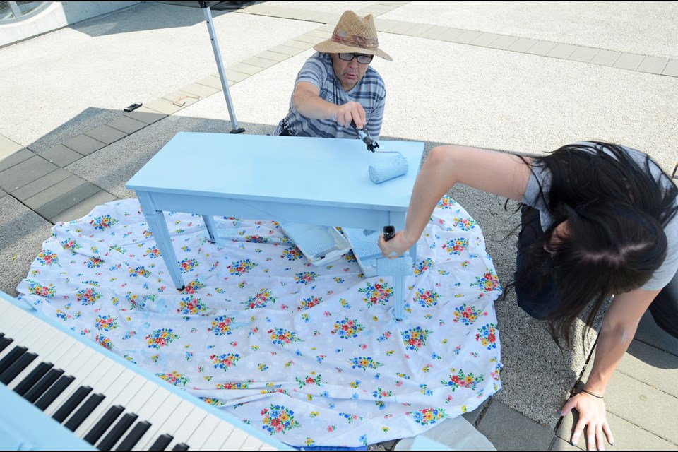Community Living Society client Leslie Fehr (left) and counsellor Megan Richter add a little colour to a public, open-air piano placed at the New West Quay by Pianos on the Street.