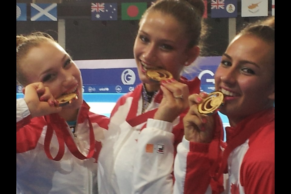 Annabelle Kovacs, right, with Canadian rhythmic gymnast teammates after winning gold in the team event.