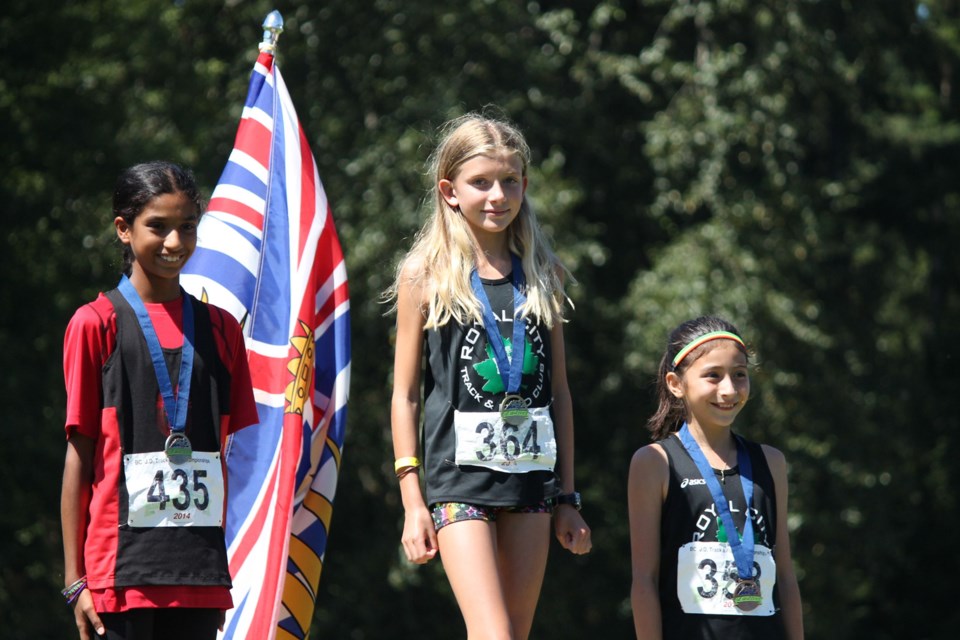 Royal City Tracksters Katie Stewart-Barnett, centre, and Milena Kalisch, right, won a gold and bronze medal, respectively in the 11-year-old girls' 1,000 metres race at the JD championships.