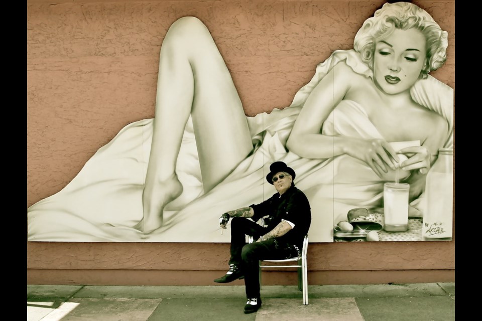 Artist Paul Archer sits in front of his Marilyn Monroe mural outside Floyd's Diner on Yates Street before the painting was taken by thieves.