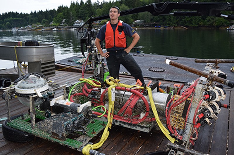 A mechanical engineering student from Camosun College, Liam Gibb of Gibsons, is poised to tackle the important task of the day: service the Folger Pinnacle platform by cleaning it with forensic meticulousness.