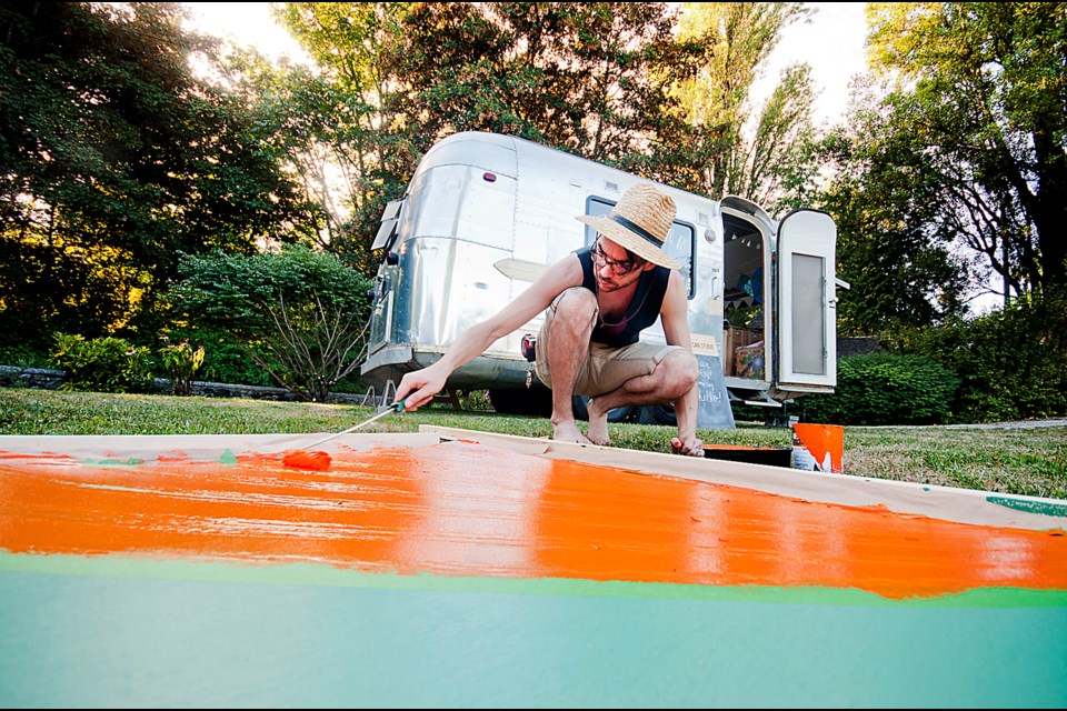 Artist Brodie Kitchen working on an outdoor sculpture in Burnaby's Deer Lake Park on Wednesday. Kitchen is using a naval camouflage technique from the First World War called dazzle painting to create a collapsible structure for the Tin Can Studio exhibit.