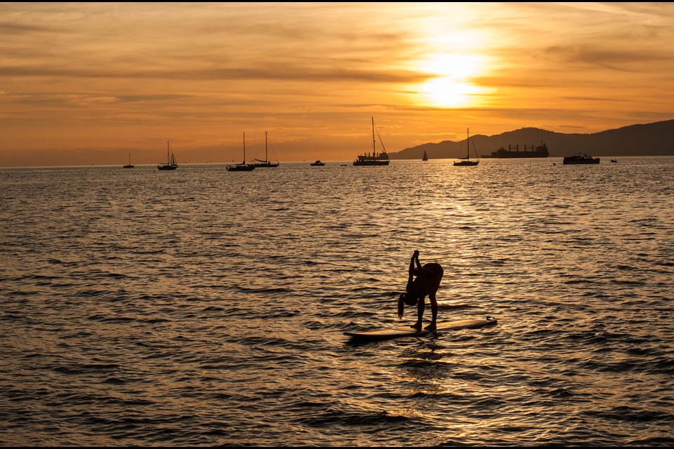 Rather than cramming herself onto the beach for Friday evening’s crowded sunset yoga class, this paddleboarder had the benefit of being within earshot of the instructor. The free class, sponsored by Lululemon, was part of KitsFest which was held this past Friday, Saturday, and Sunday at Kits Beach. Photograph by: Rebecca Blissett