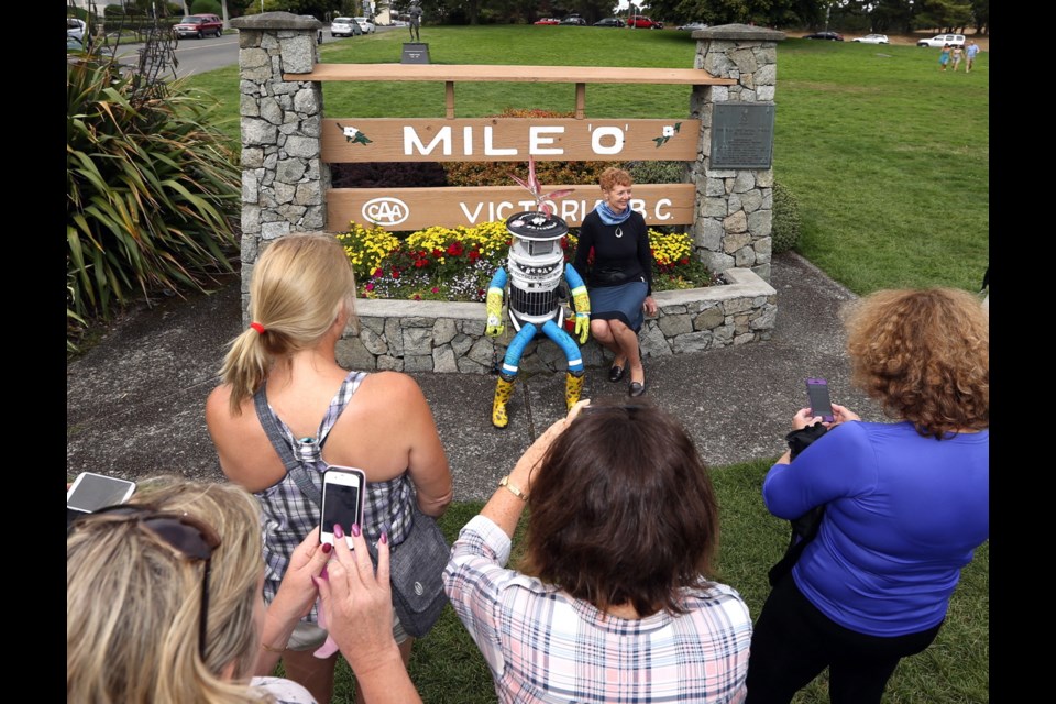 Hitchhiking robot hitchBOT arrives at Mile Zero and is surrounded by fans