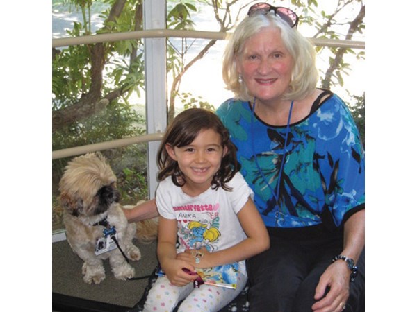 Bandit and his owner Lori Brisbin (right) sit with one of the young readers that the six-year-old shih tzu lends a keen ear to during the Storytime With a Dog program at the Steveston Library. Photo submitted