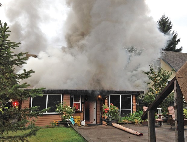 Smoke billows out a home on East Third Street.