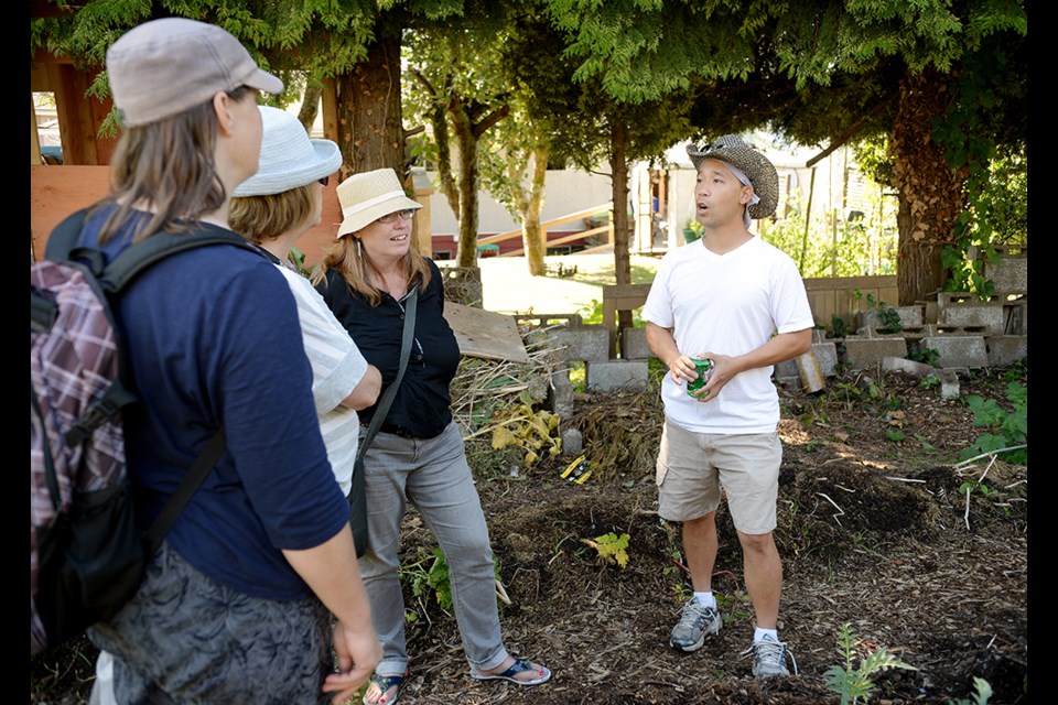 Winston Wong leads a tour through his neighbour's backyard, which he and his family use for gardening.