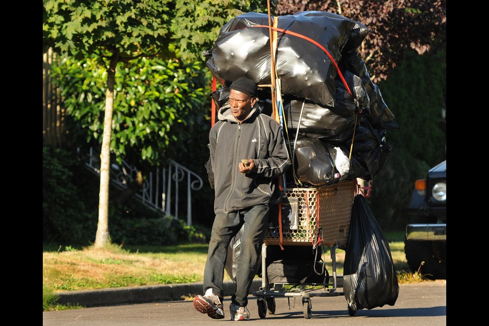 Dino Blackette gingerly walks his cart loaded with eight bags of recyclables down the 37th Avenue hill near Queen Elizabeth Park Monday morning. photo Dan Toulgoet