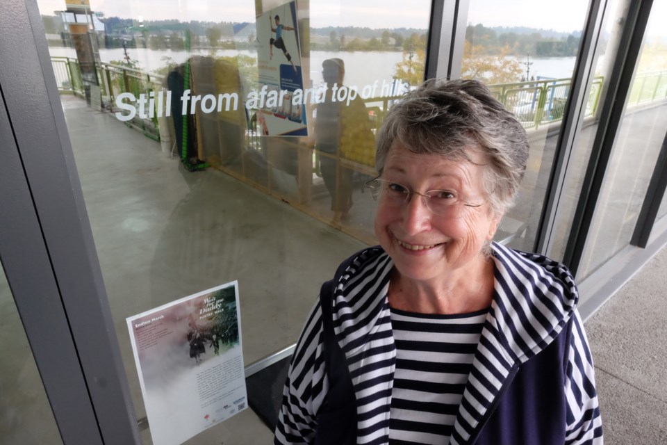 Carla Evans outside the upper level at River Market, where her poem adorns a window as part of the Wait For Me Daddy Poetry Walk.