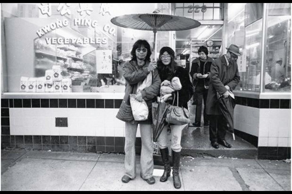 The man holding the umbrella was known as Blackie. He's with his girlfriend. Wong-Chu liked the idea that he was holding a Chinese parasol in the rain. Kwong Hing Co Vegetables was one of the fixtures in Chinatown. It closed about a year ago.