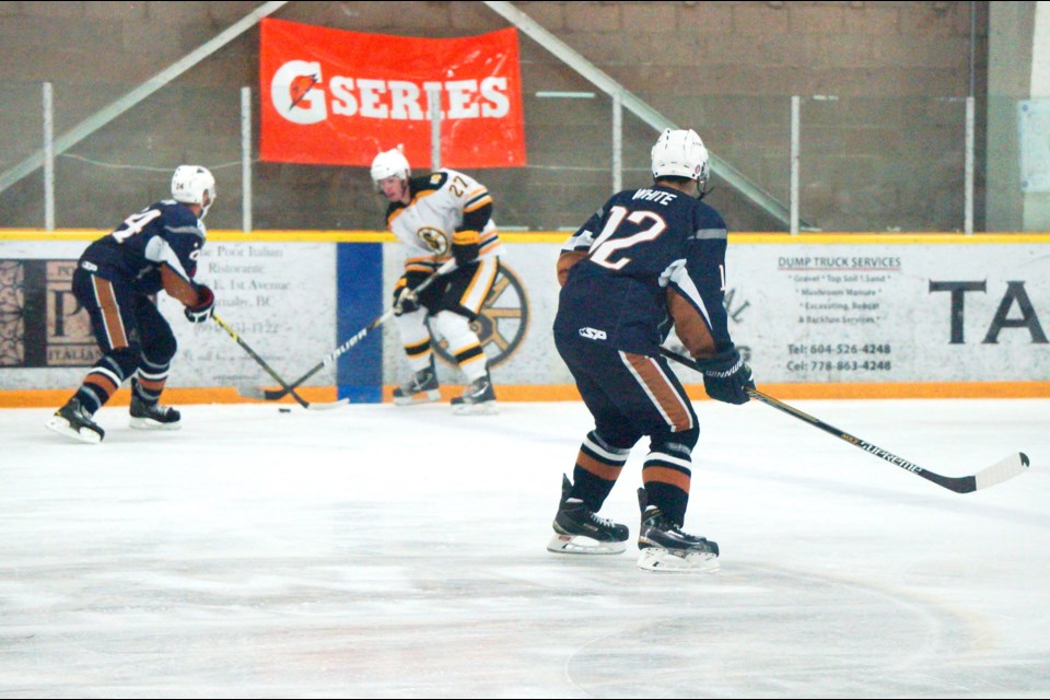 Hot potato: Grandview Steeler Sean Norbury (27) tries to get control of the puck from a Delta Ice Hawks’ player. The Steelers were defeated 5-2 at home at the Burnaby Winter Club on Oct. 5.