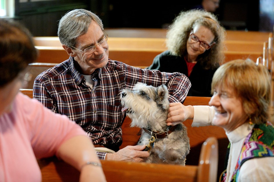 Wagner the dog is given a blessing by Rev. Emilie Smith at St. Barnabas Church on Saturday.