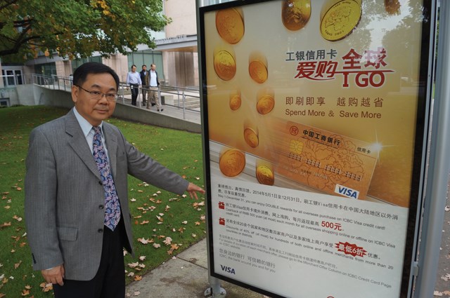 Coun. Chak Au stands next to an almost entirely Chinese advertising board at a bus stop near city hall. Au feels the signs are symptomatic of a more complex cultural issue.