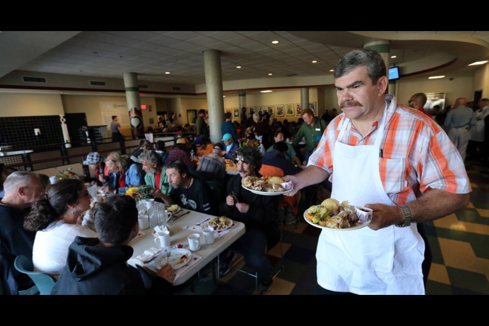 Former VicPD deputy chief John Ducker serves up loaded plates for an appreciative crowd.