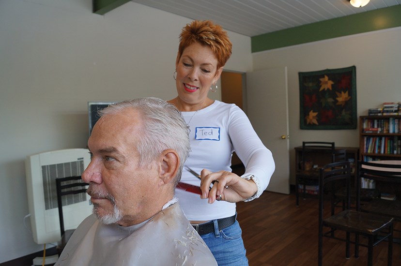 Ted Hunter, a hairstylist, cuts Scott Newcombe's hair on Homeless Connect day at St. Alban Church. Oct. 2014