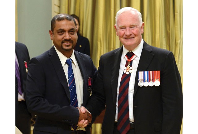 Francis Nand, left, receives his Medal of Bravery from David Johnston, Governor General of Canada, at a ceremony at Rideau Hall, Ottawa on Tuesday. Married father-of-two Nand was one of six heroes who plucked passengers from the burning fuselage of a plane which crashed on Russ Baker Way in 2011.