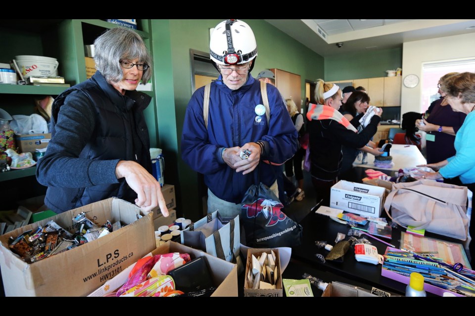 Fran Fettig-Winn, left, helps Howard Cooper gather toiletries during Project Connect, an annual fair held at Our Place on Tuesday, Oct. 21, 2014.