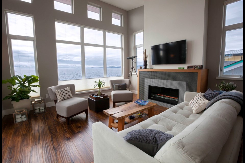The second floor living room looks out on the sea and sky, not the road. Floors are engineered acacia hardwood, and a brick on the mantle is a relic saved from the original home's chimney.