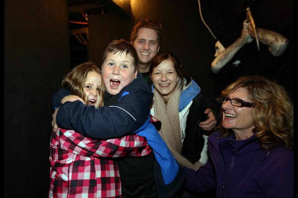 Kayleigh Baker, 6, hugs brother Kenyon, 9, while Dallas Attermann, back, with Megan Rozon and Adele Barnswell watch inside the family-friendly haunted house.