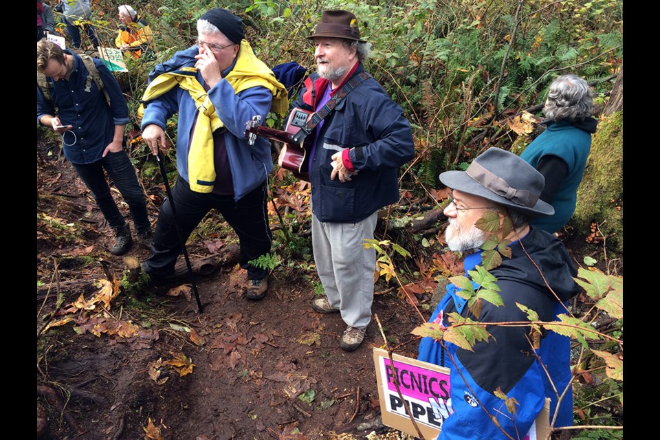 On the scene at bore hole area 2, a clearing in the woods, roughly five-minutes downhill from Centennial Way. Protesters gather and sing songs after others confronted Kinder Morgan work crews, who showed up on site, hoping to establish a safety zone to continue survey work for a new pipeline route.